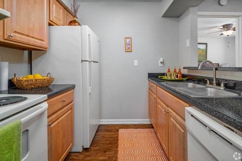 a kitchen with white appliances and granite counter tops
