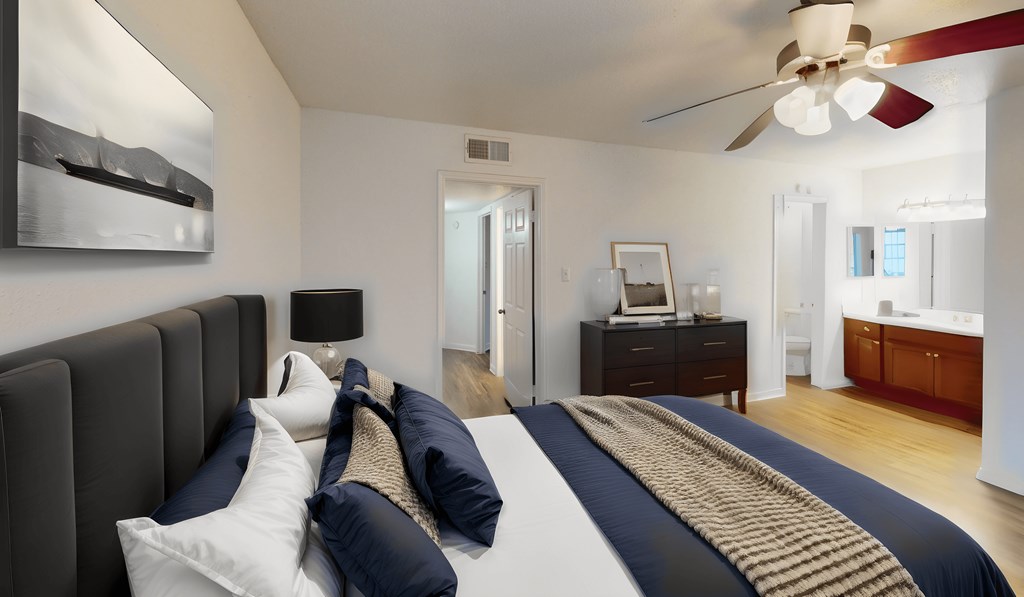 a bedroom with a large bed and a ceiling fan