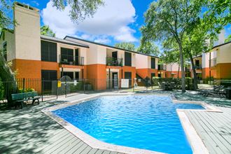 an apartment building with a swimming pool and trees