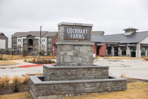 A stone monument with Lockhart Farms 1911 engraved on it at Lockhart Farms Apartments, Lockhart 78644
