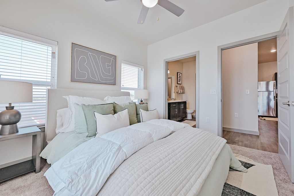 A bedroom with a large bed and a ceiling fan at Lockhart Farms Apartments, Lockhart
