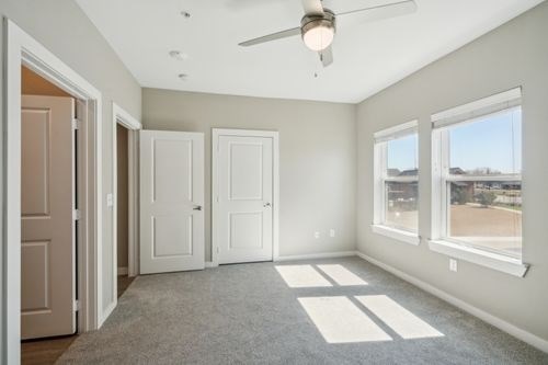 A room with a ceiling fan and three doors at Lockhart Farms Apartments, Lockhart 78644