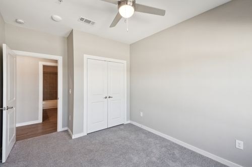 A room with a ceiling fan and two doors at Lockhart Farms Apartments, Lockhart 78644