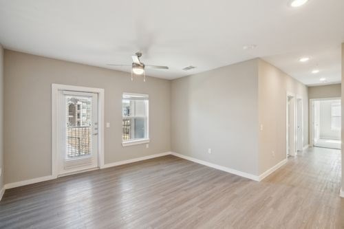 A spacious room with a ceiling fan and sliding glass doors at Lockhart Farms Apartments, Lockhart, TX