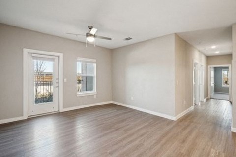 A spacious room with wood flooring and a ceiling fan at Lockhart Farms Apartments, Lockhart, TX, 78644A 