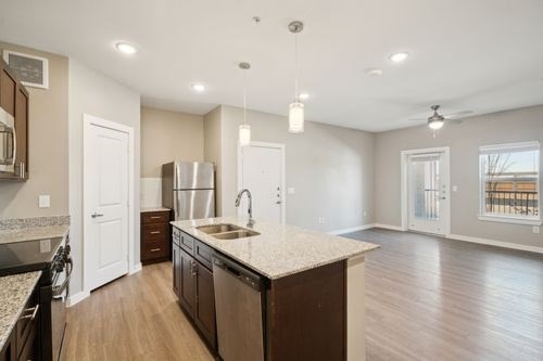 A kitchen with a white countertop and wooden floors at Lockhart Farms Apartments, Lockhart, TX