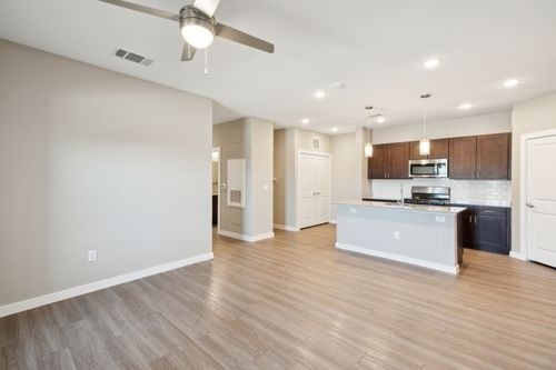 A spacious kitchen with a white countertop and wooden cabinets at Lockhart Farms Apartments, Texas