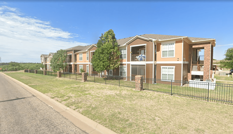 A row of houses with a black fence in front.