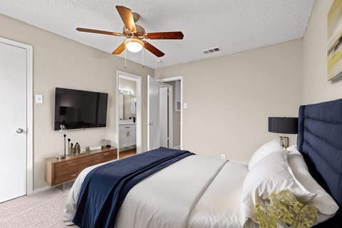 a bedroom with a large bed and a ceiling fan
