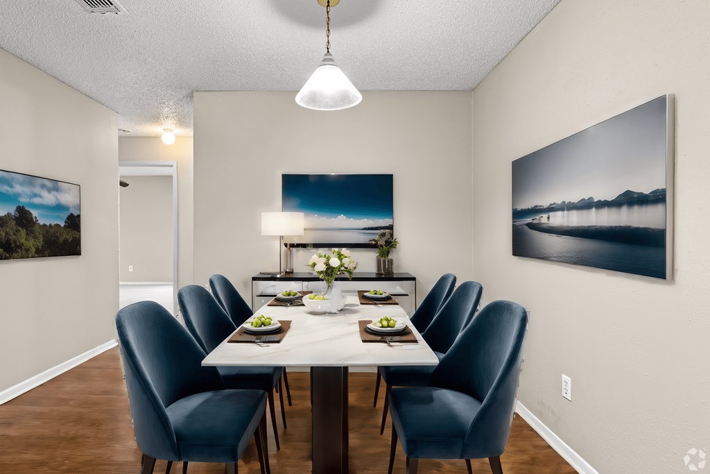 a dining room with a white table and blue chairs
