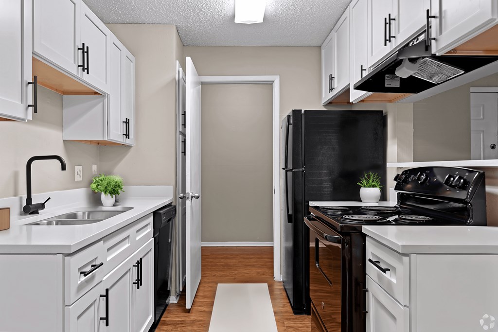 a kitchen with white cabinets and a black stove and refrigerator