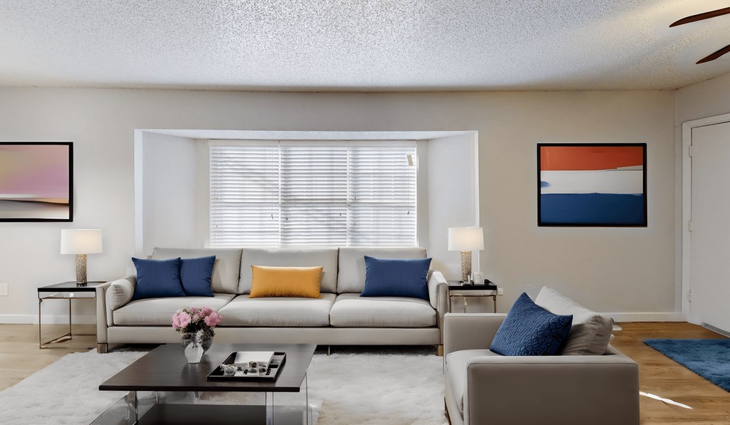 a living room with a couch and a coffee table and a window