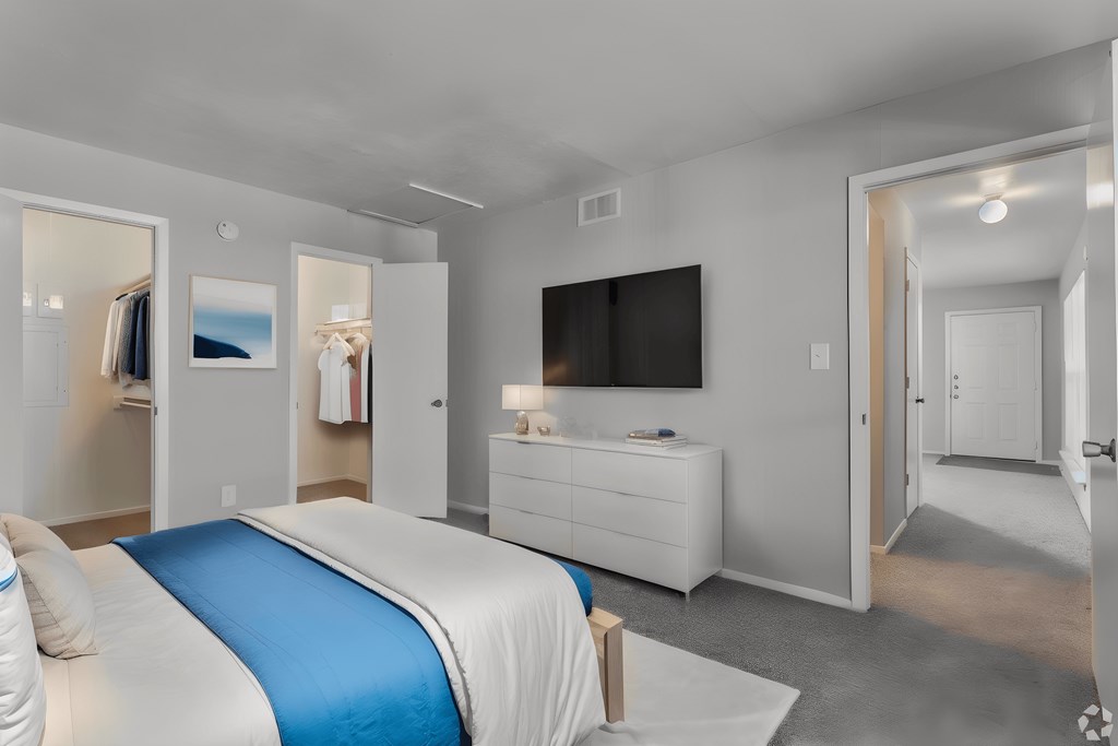 a bedroom with a large bed and a tv on the wall