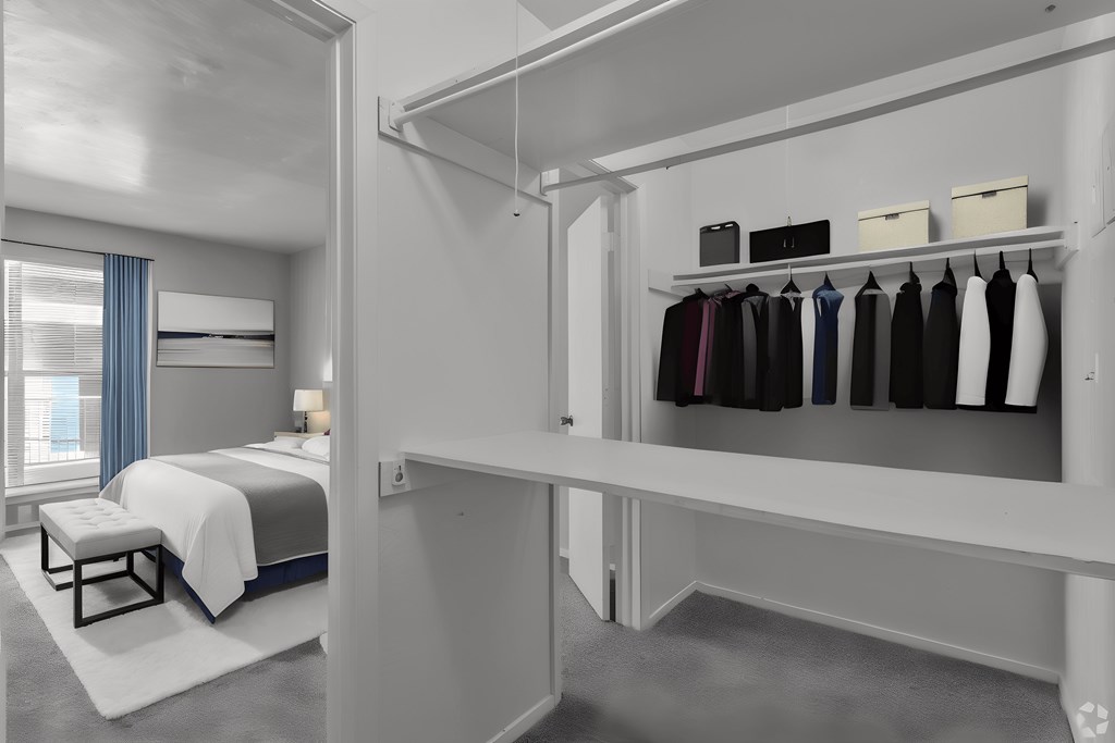 a bedroom with a bed and a closet with a rack of clothes