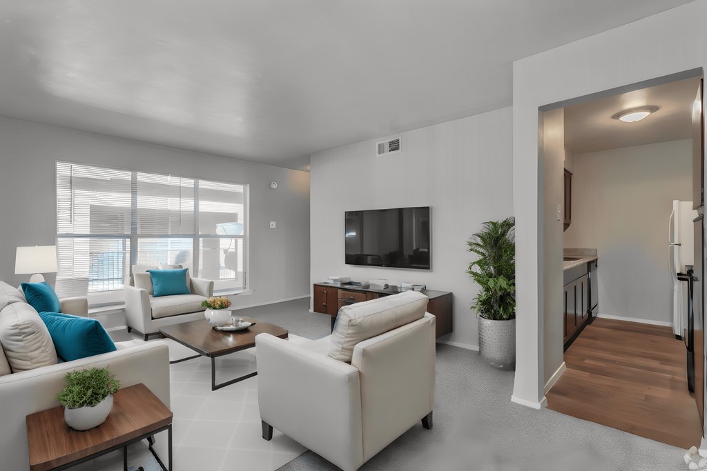 a living room with white furniture and a television