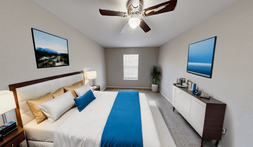 a bedroom with a large bed and a ceiling fan
