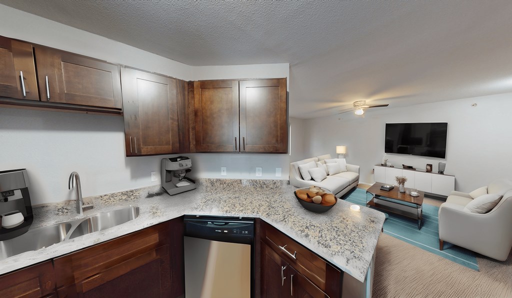 a kitchen and living room with a granite counter top