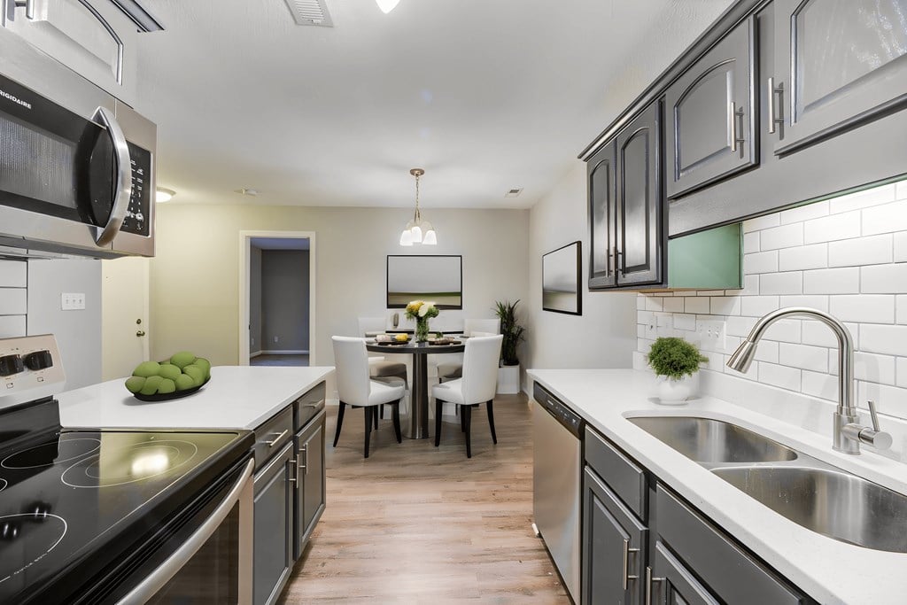view of kitchen and dining area with stainless steel appliances and white counter tops and wood