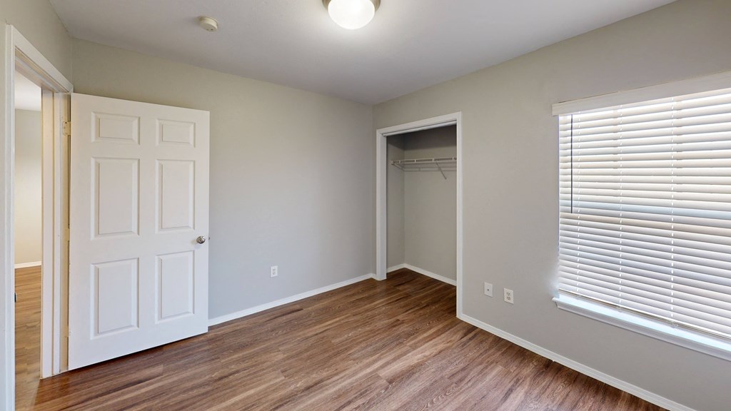Bedroom with faux wood floors and a closet