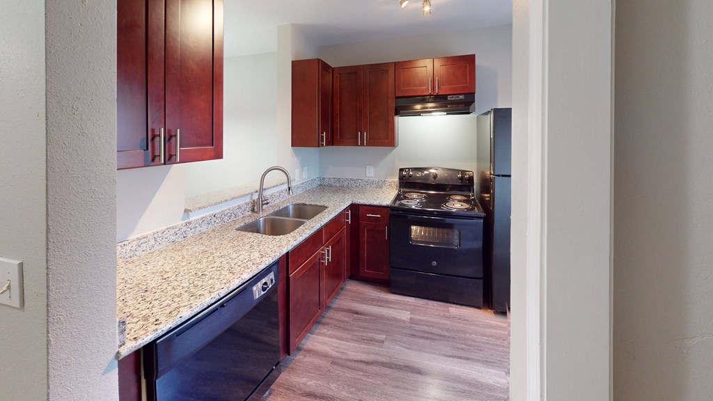 a kitchen with granite counter tops and black appliances