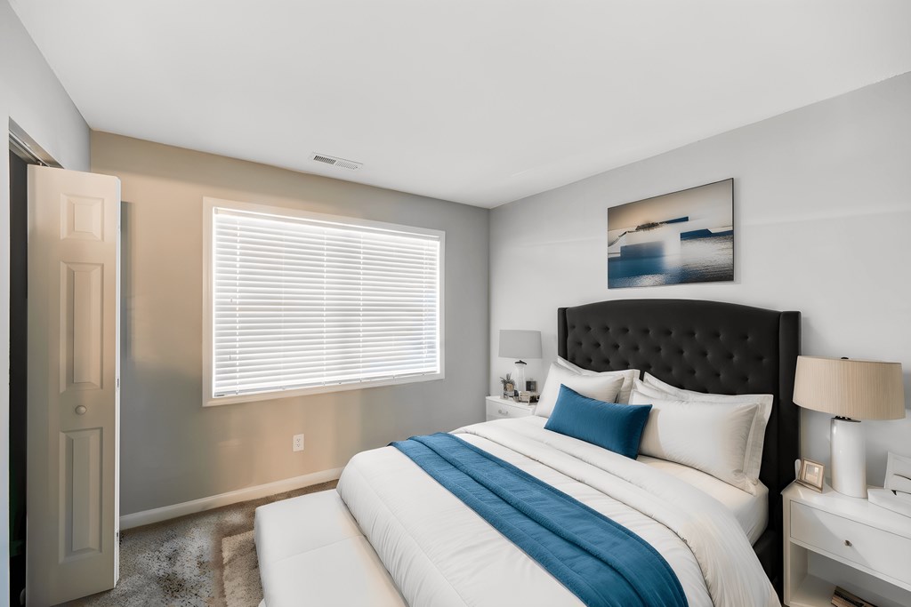 a bedroom with a large bed and a window