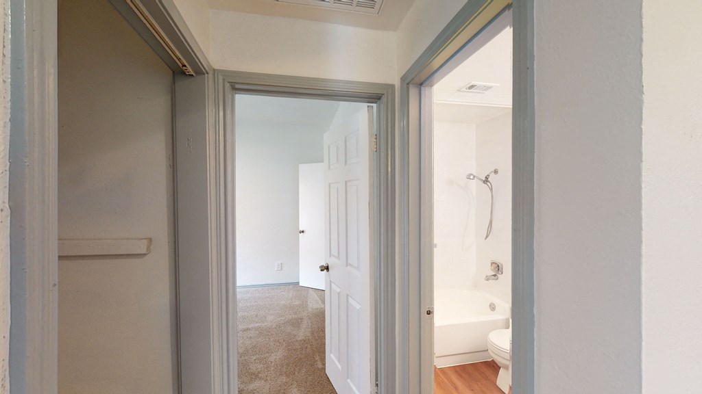 a bedroom with a door to a bathroom with a tub and a shower