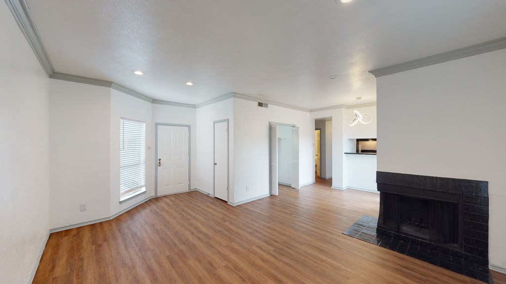 A living room with a fireplace and a wooden floor.