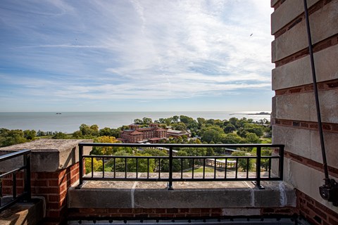 A balcony overlooks a view of the ocean and buildings.