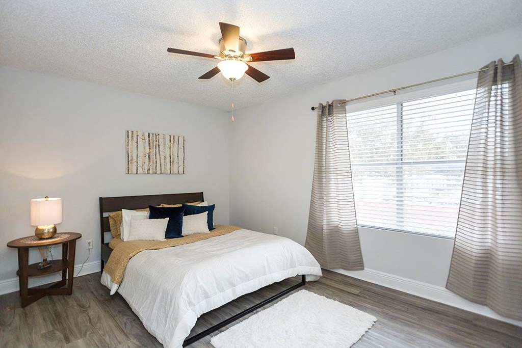 a bedroom with a bed and a ceiling fan