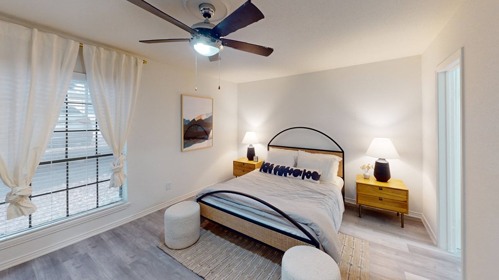 a bedroom with a large bed and a ceiling fan