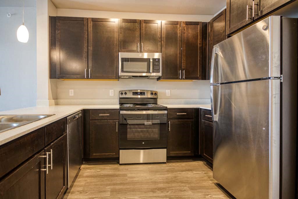 a kitchen with stainless steel appliances and wooden cabinets