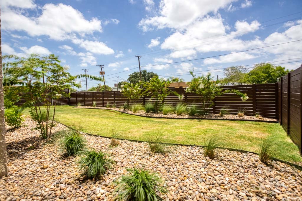 a backyard with a grass lawn and a fence