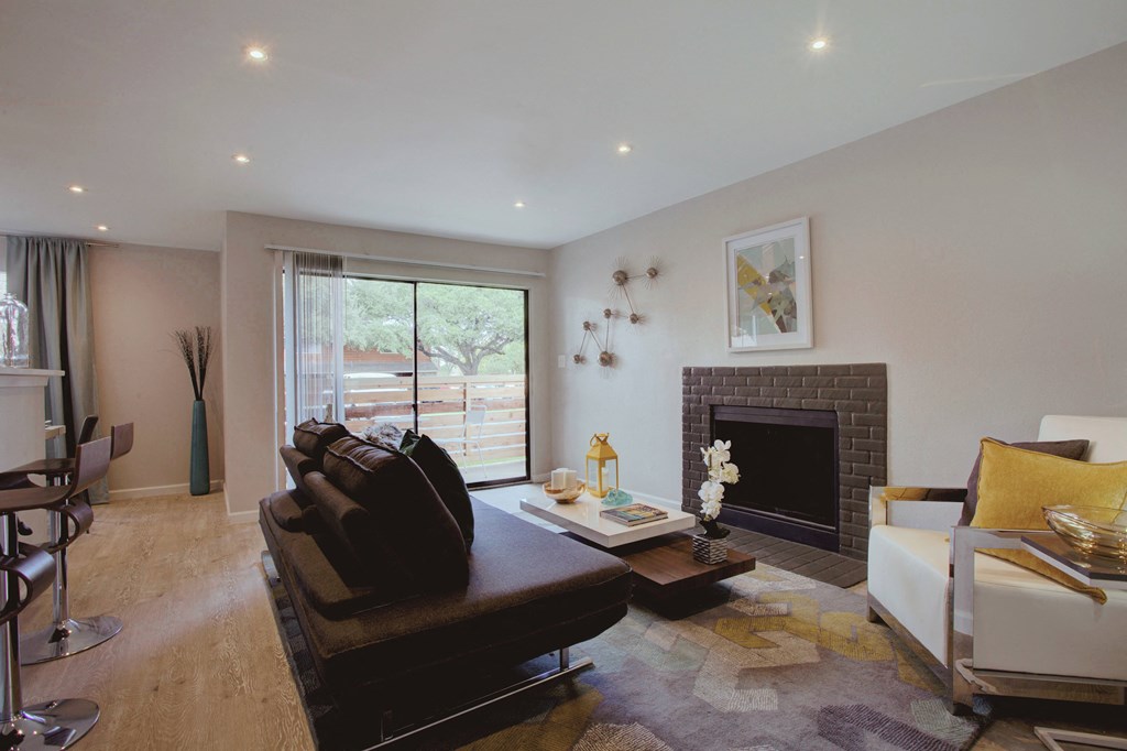 a living room with a leather couch and a fireplace