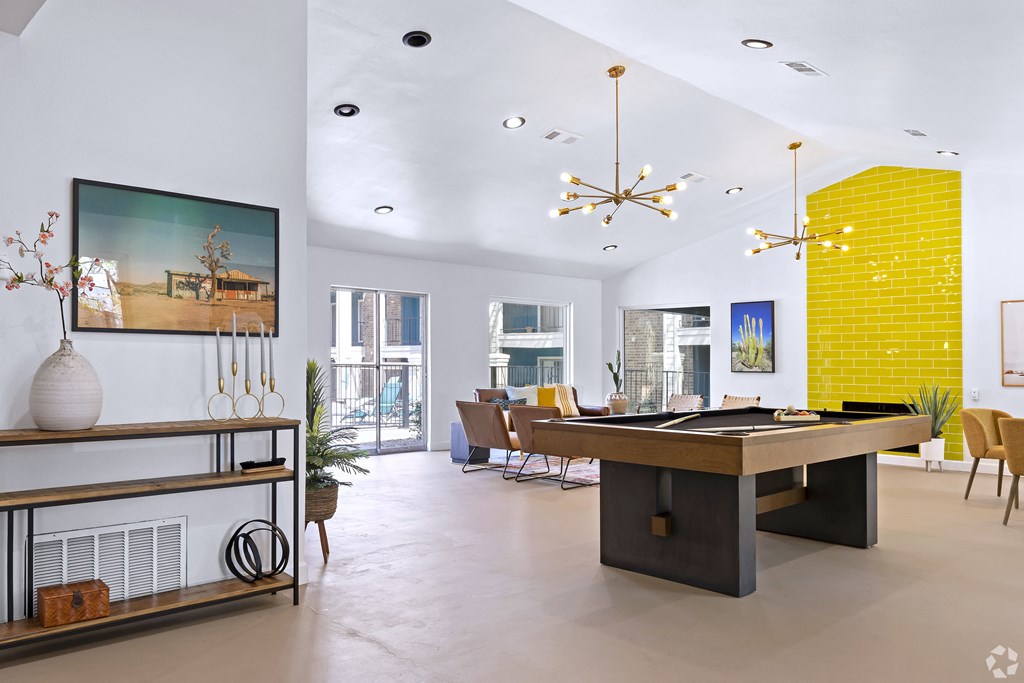 a living room with a pool table and a dining room in the background