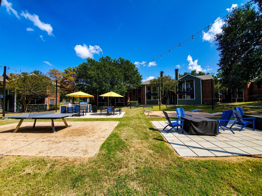 a patio with tables and chairs and umbrellas in a park