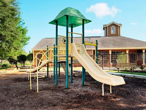 Playground with tower slide and climbing features at Country Oaks Apartments, Texas