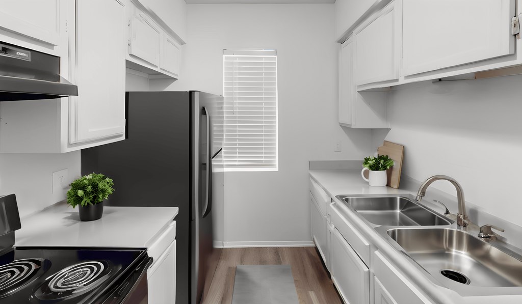 a kitchen with white cabinets and a black refrigerator