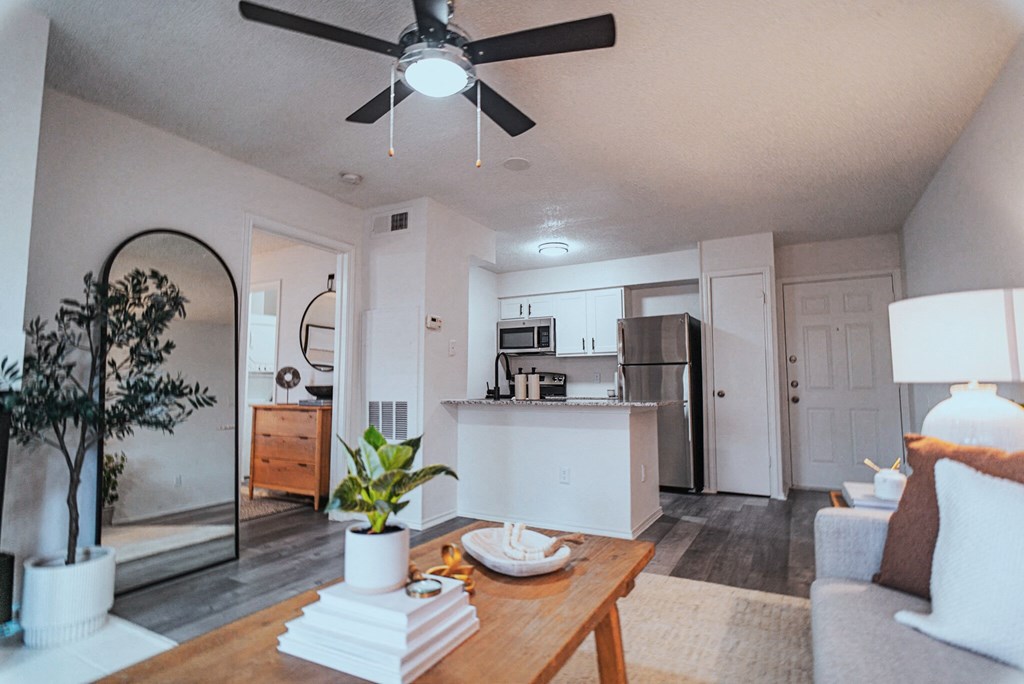 an open living room and kitchen with a ceiling fan