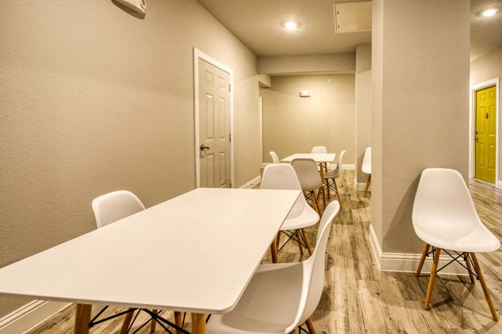 a long row of white tables and chairs in a large room