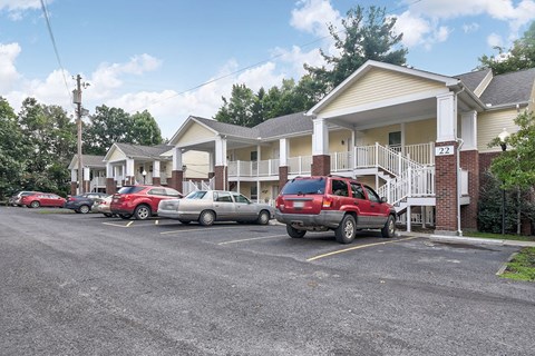 A parking lot with cars and a building in the background.