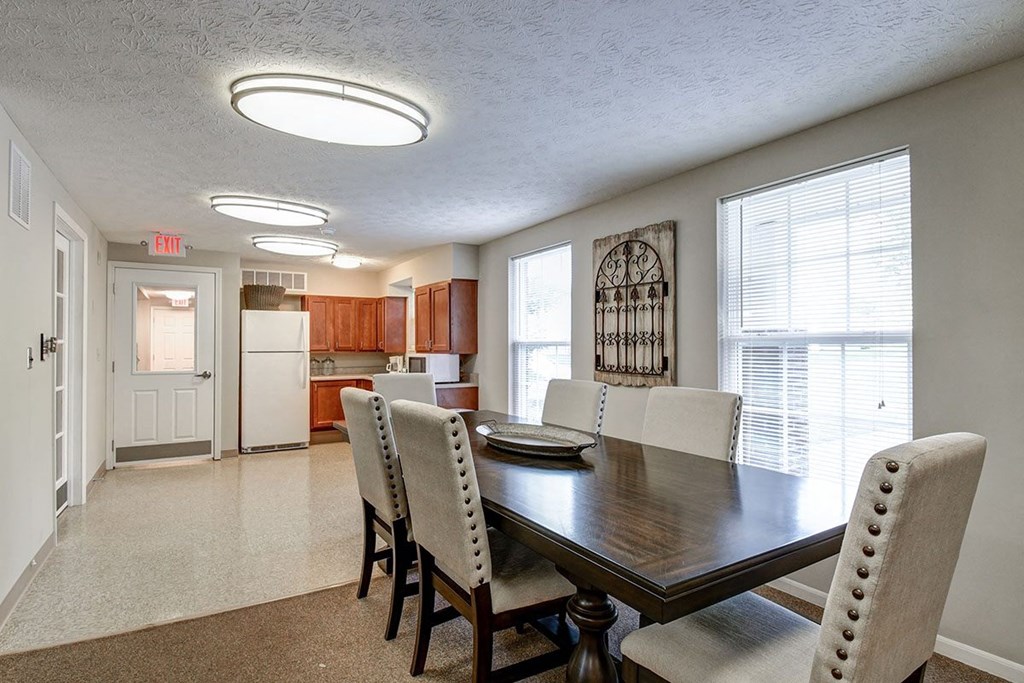 A dining room with a wooden table and chairs.