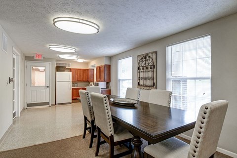 A dining room with a wooden table and chairs.