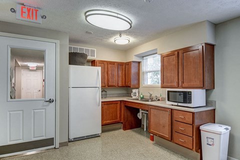 A kitchen with a white refrigerator and brown cabinets.