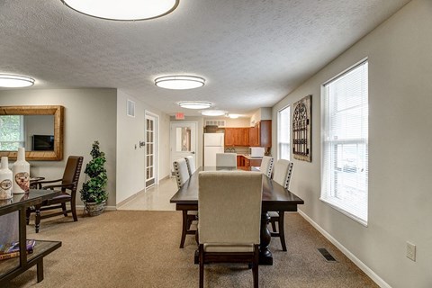 A living room with a couch, chairs, and a dining table.