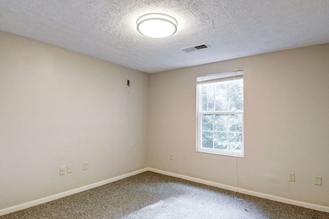 A room with a window and a ceiling light.