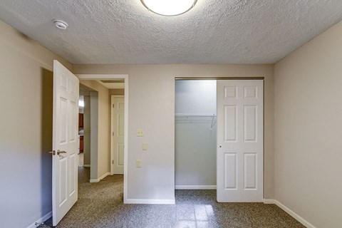 A hallway with a white door on the right and a brown door on the left.