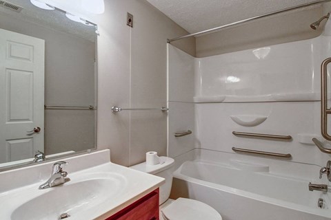 A white bathroom with a sink, toilet, and bathtub.