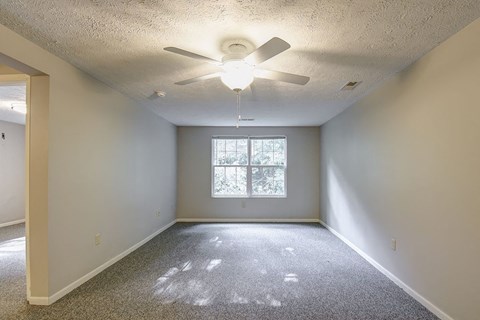 A room with a ceiling fan and a window.