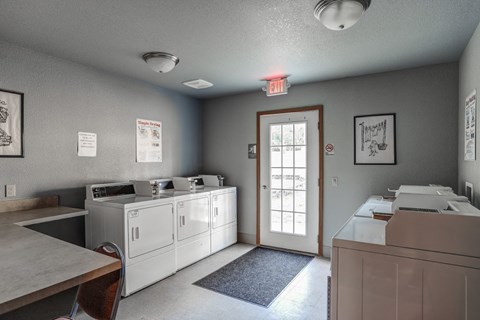 a laundry room with two washers and two dryers