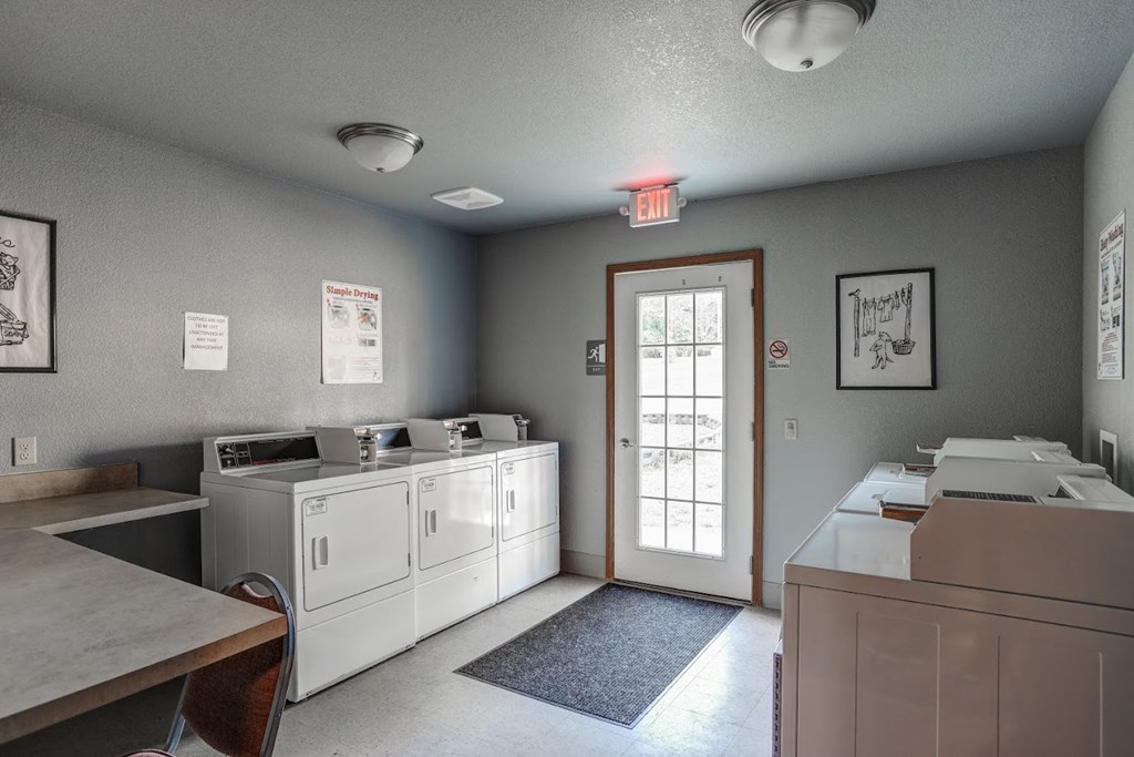 a laundry room with two washers and two dryers